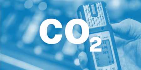 Image of a man's hand holding a gas monitor. The image has a text overlay that reads CO2.