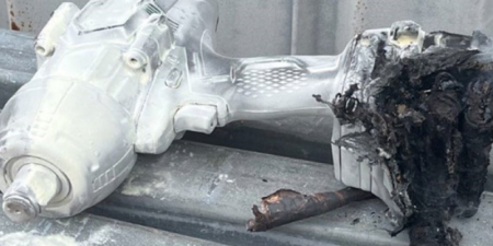 A drill lying on its side with a burnt-out battery pack. 